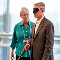 Image of a person training someone on the use of a walking cane
